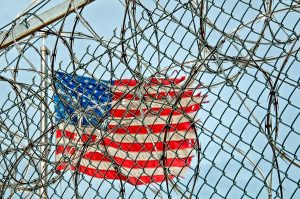 Barbed wire fence in front of an American flag